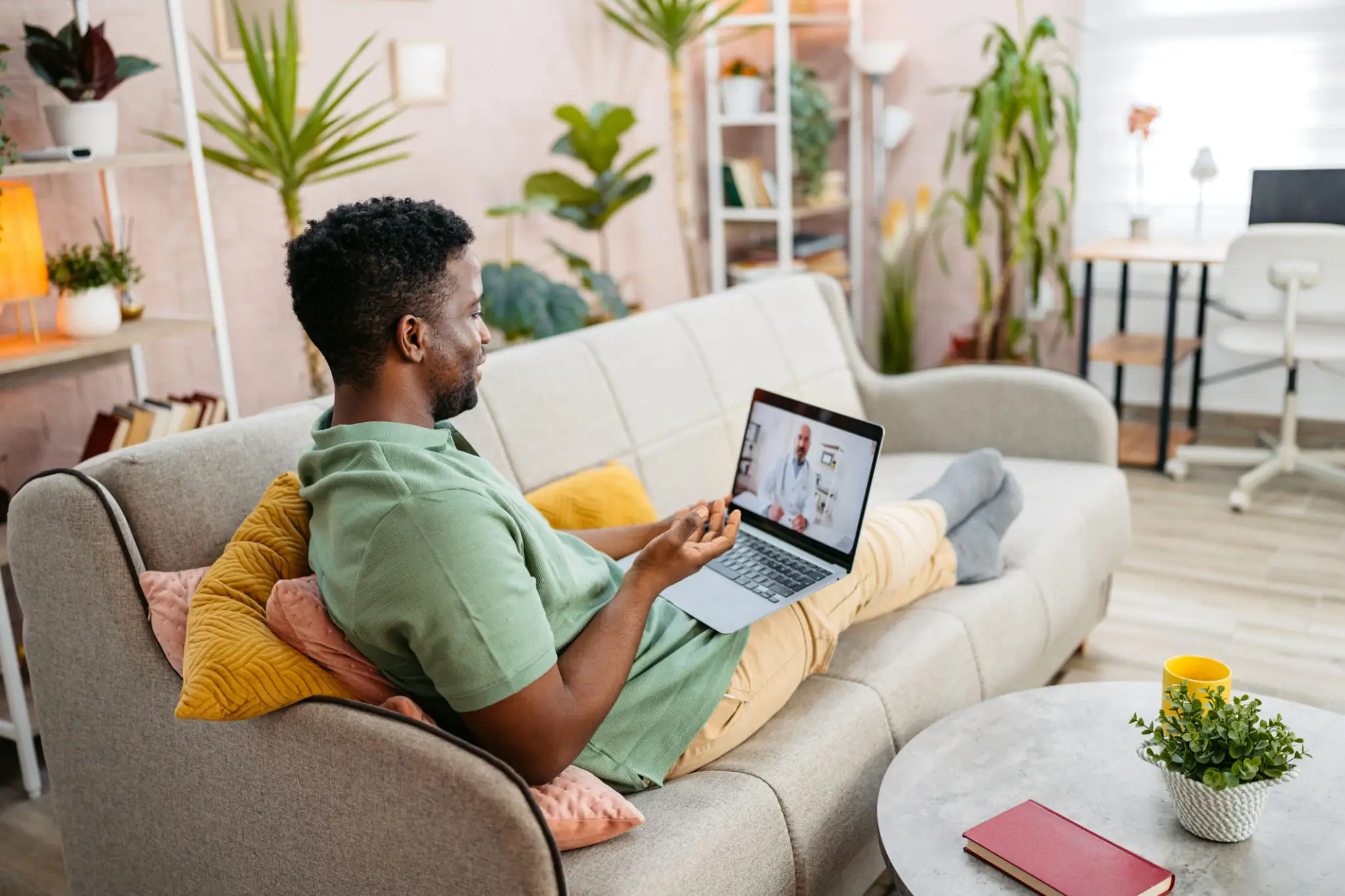 Man relaxing on couch using laptop at home.