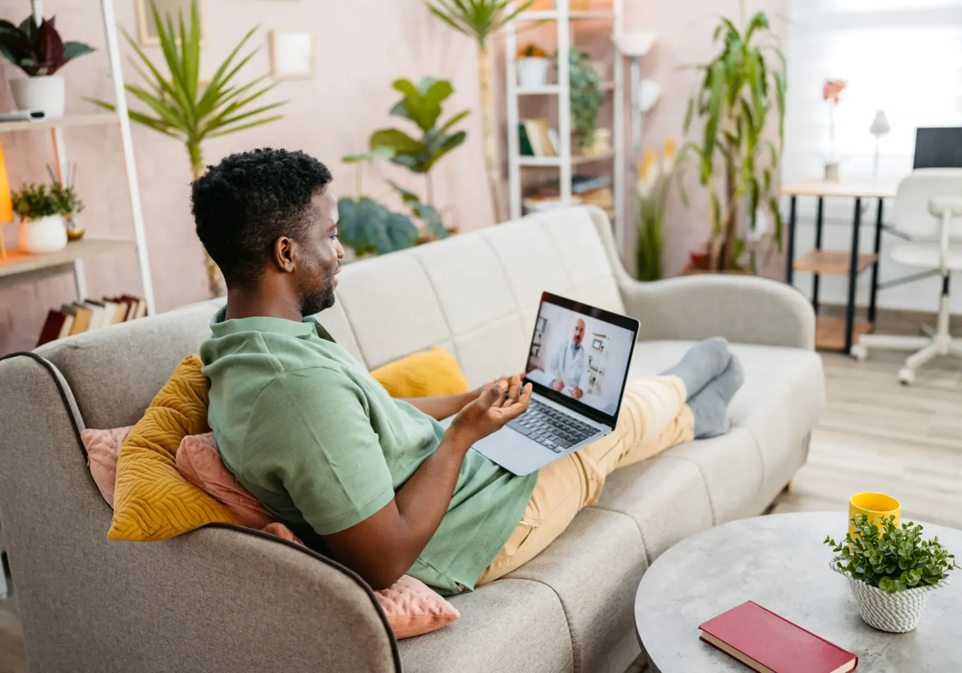 Man relaxing on couch using laptop at home.